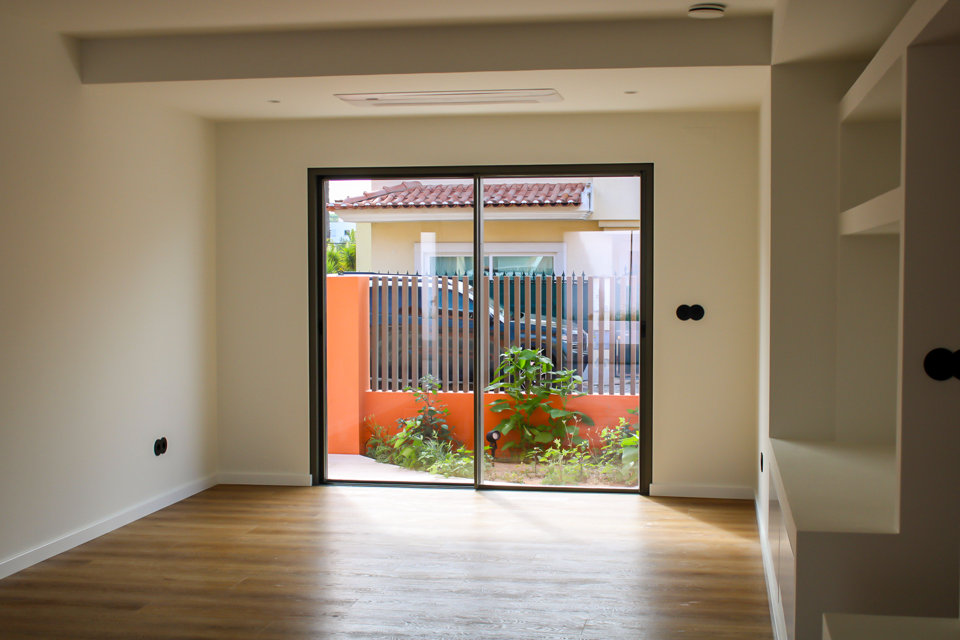 Sala ampla com porta de correr em alumínio antracite e jardim exterior